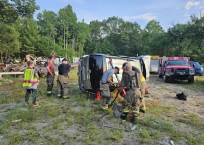 Members work on a vehicle on its side