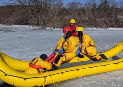 Rescuers bring a person into the inflatable rescue boat on the ice
