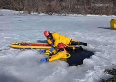 A rescuer with a rescue board at the hole in the ice