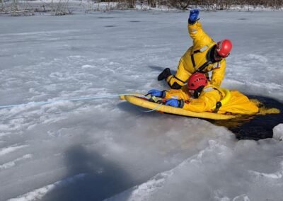 A rescuer pulls a person out of the water onto a rescue board
