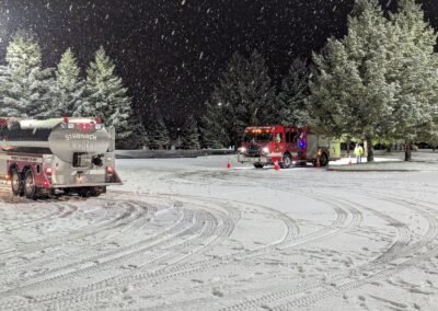 The Stronach tanker and an engine working the course in falling snow, December 2, 2024