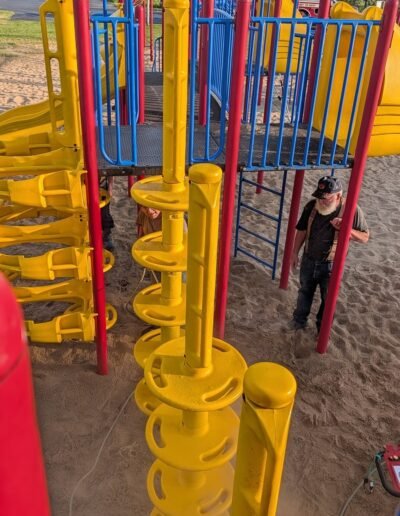 A member power-washes the playground equipment at Stronach Park