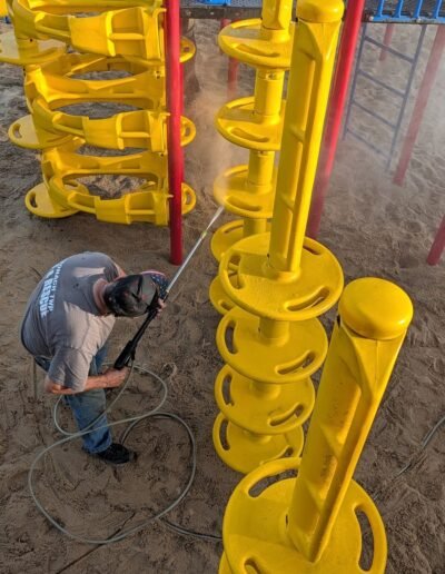 Members clean the playground equipment at Stronach Park