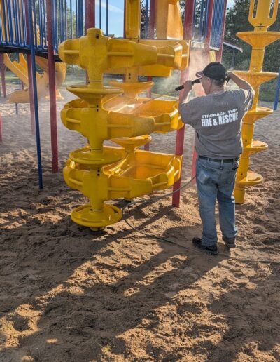 Members clean the playground equipment at Stronach Park