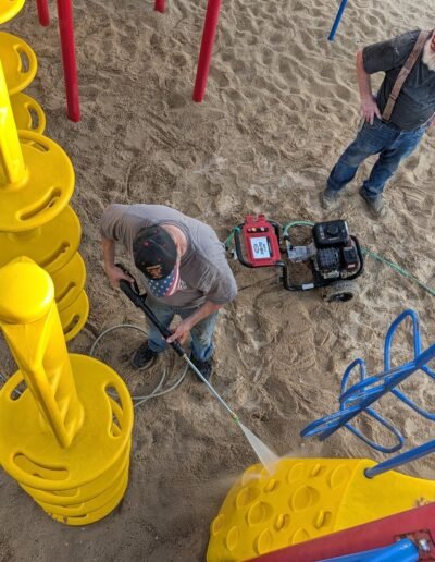 Members clean the playground equipment at Stronach Park