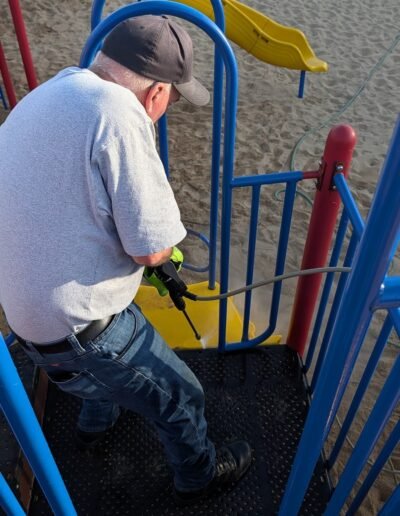 Members clean the playground equipment at Stronach Park