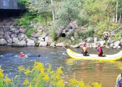 A swimmer and a crew in the raft practice a river rescue