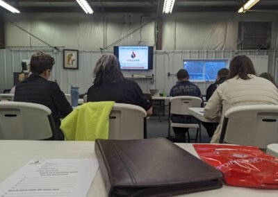 Class members seated in a training room facing a presentation screen