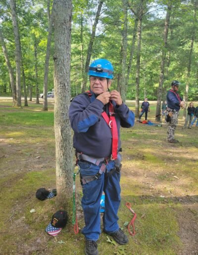 A firefighter in helmet and climbing harness getting ready to climb during tree stand rescue training, September 12, 2026