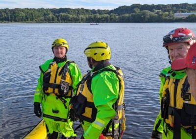Members in water rescue suits at the water’s edge